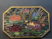 Close-up view of the rectangular octagonal brooch showing detailed multicolor lotus flower enamel design with gold metal lines and black background.