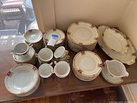 Full overview of the dinnerware arranged on table showing plates, cups, bowls, platters, gravy boat and creamer.