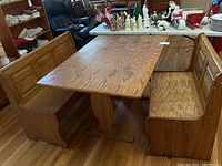 Overall shot of oak table flanked by two benches angled view