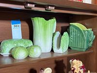 Full shelf view showing all vegetable motif tableware items including butter dish, salt and pepper shakers, pitcher, napkin holder, and corn vase.