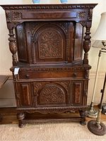 Front view of the vintage wooden bar/buffet showing full structure with carved floral motifs and turned wooden columns.