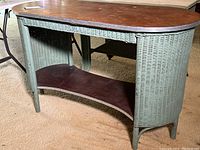 Vintage wicker table showing overall front view including wooden top and shelf, highlighting condition and design.