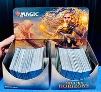 Two booster display trays filled with Magic the Gathering Modern Horizons cards, showing the card backs and display box front art.