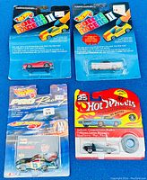 Four unopened new Hot Wheels cars on original 90s style blister cards shown from front. Different car models visible with original pricing stickers on the cards.