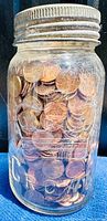 Close-up of the Crown sealer jar filled with old pennies showing jar and coin details