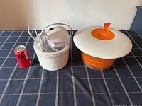Two items on table, ice cream maker and salad spinner with soda can for size comparison.