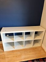 Front view of white IKEA Lack shelf unit with 8 open square shelves.