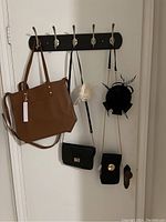 Four purses and two fascinators hung on wall hooks.