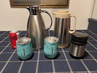 Full set including two thermal carafes, two turquoise Corkcicle tumblers, stainless steel insulated food jar, and a soda can for scale