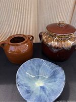 Photo of two brown bean crocks and one blue glazed bowl showing overall lot contents