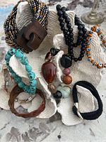 Lot of 8 bracelets displayed on coral-shaped stand showing variety of styles and materials.