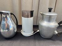Photo showing three items together: Puralum Italy stainless steel pitcher on the left, Braun coffee grinder in the middle, and vintage aluminum coffee pot on the right.