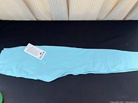 Full length view of light blue leggings laid flat