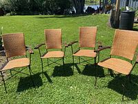Four Pier One rattan dining chairs on grass, showing overall set and condition