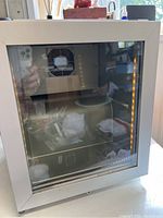 Front view closed showing glass door with interior LED lighting visible