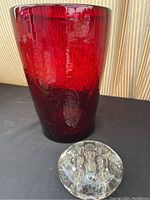 Photo of oversized red glass vase with textured surface and clear glass flower frog.
