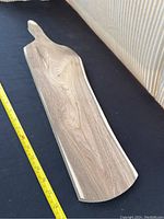 Top view of handmade wooden serving board showing natural grain and handle shape.