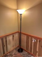 Full view of first standing lamp: oil rubbed bronze with creamy white globe in a corner, showing height and base.