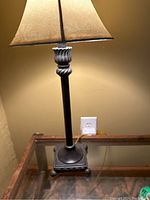 View of table lamp showing the oil rubbed bronze base with decorative elements and the cream leather shade.