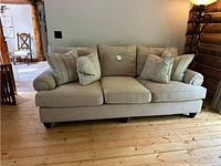 Front view of sofa showing overall size, upholstery and four accent pillows