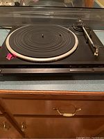 Front view of Technics SL-QD33 turntable with tonearm and platter showing rubber mat and dust cover closed