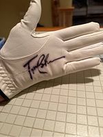 White leather women's golf glove signed by Tom Lehman on palm side showing signature.