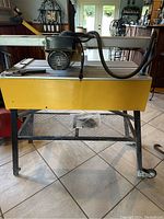 Full view of saw on stand showing table and motor assembly