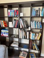 Bookshelf containing a variety of books with some Mad Magazines stacked at bottom