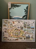 Both framed artworks shown together, one a Saanich Inlet coastal landscape and the other a Saturna Island illustrated map.