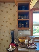 Photo of kitchen counter with SodaStream machine, glassware, Asian tea set basket, dishes, bowls, and other items arranged