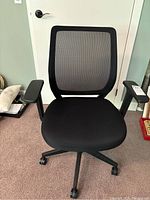 Front view showing cushioned seat, mesh backrest, armrests, and rolling casters on base.