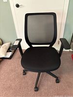 Front view of black mesh office chair showing seat, backrest, and armrests