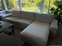 Full front perspective of beige sectional sofa with chaise lounge