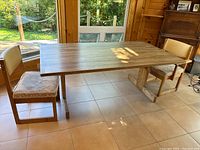 Overview of rectangular wood table with two chairs in room
