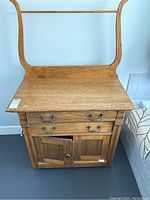 Front view of vintage oak dresser with two drawers and lower cupboard. Shows handles and drawer alignment.