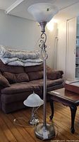 Photo showing the 56-inch floor lamp and 17-inch table lamp together with brown couch in background. Lamp cords visible and appear damaged or twisted.