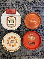 Four vintage metal beer trays on carpet, shows whole lot