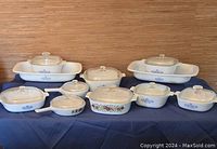 Front view of Cornflower pattern dishes and lids on blue cloth
