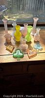 Photo showing assorted pastel vintage glassware including bud vases and card suit shaped dishes