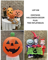 Full display of all Halloween items on a table with inflatables to side