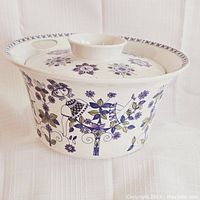 Side view of the small lidded serving bowl showing Turi Lotte pattern with floral and character design.