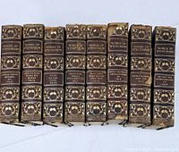 Eight vintage books, Robert Louis Stevenson works, spines showing titles and decorative gold embossing