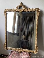 Front view of the rectangular mirror showing ornate gilded wood frame with leaf, scroll, and pagoda motif.