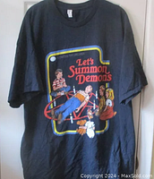 Full view of navy blue t-shirt showing 'Let's Summon Demons' graphic of children around pentagram.