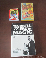 Three magic books displayed flat, titles visible