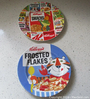 Top-down view of two vintage Kellogg's plates on a white speckled surface, showing overall designs and condition.