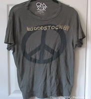 Front view of dark brown Woodstock 69 T-shirt with peace sign and text graphic