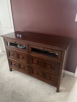 Front view of low wide dresser showing two open cubbies and six drawers