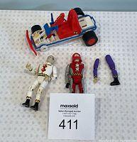 Lot contents including two Crash Test Dummies figures and one toy car with red seat and blue frame.