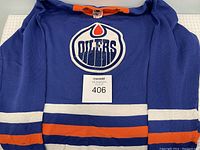 Full front view of the blue Edmonton Oilers kids sweater showing logo and stripes.